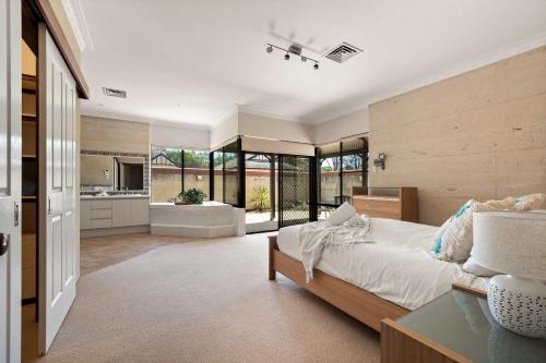 a bedroom with a large bed and a kitchen at Carinya Cove - swimming pool, pet friendly, fireplace in Dunsborough