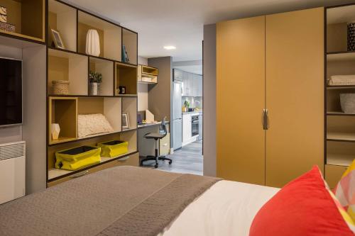a bedroom with a bed and a kitchen at Comfortable Studio For 2 In Leeds with Free Grab&Go Breakfast in Headingley
