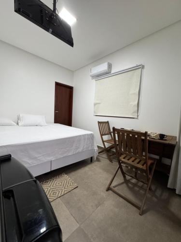 ein Schlafzimmer mit Bett, Stuhl und Schreibtisch in der Unterkunft Casa vista mar a 20 metros da praia de garça torta em Maceio in Maceió