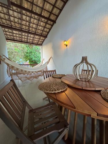 Zimmer mit einem Tisch, Stühlen und einer Hängematte in der Unterkunft Casa vista mar a 20 metros da praia de garça torta em Maceio in Maceió
