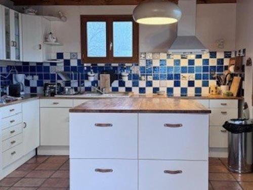 - une cuisine avec des placards blancs et du carrelage bleu et blanc dans l'établissement Chalet spacieux, 14 pers., proche pistes, cheminée, terrasse, WIFI, parking, Crest-Voland - FR-1-733-77, à Crest-Voland