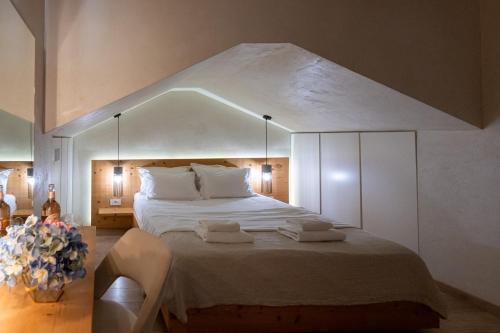 a bedroom with a large bed with two towels on it at Panellinion Luxury Rooms in Kalamata