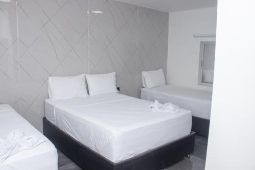 a bedroom with two beds and a bath tub at Hotel Mall plaza in Santa Marta