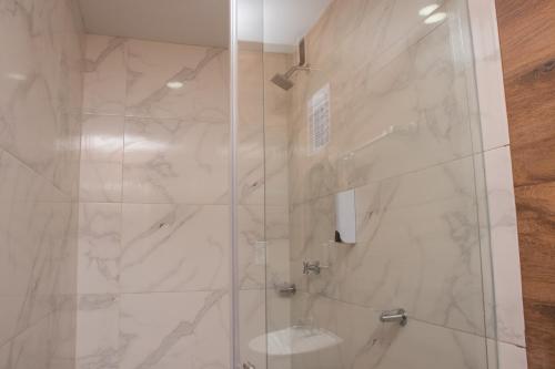 a bathroom with a shower with a glass door at Hotel Mall plaza in Santa Marta