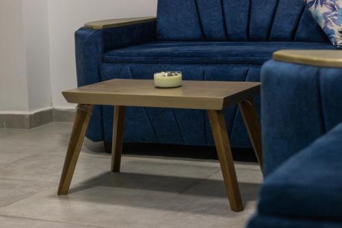 a coffee table with a candle on it next to a blue couch at Hotel Mall plaza in Santa Marta