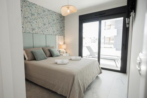 a bedroom with a large bed and a balcony at Azure Libra Apartment Flamenca Village in Orihuela Costa
