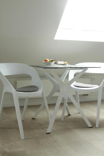a white dining table and two white chairs at Campus Boardinghouse in Aachen