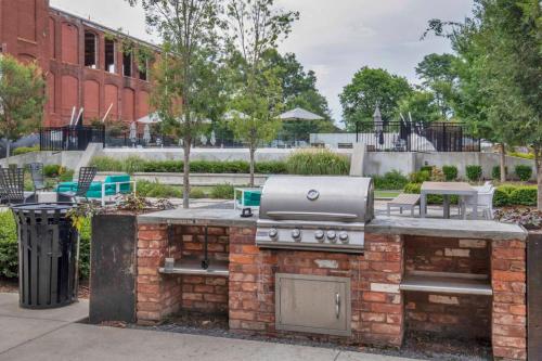 a barbecue grill in a park with a trash can at Urban Escape Industrial 2BR 2BA in Greenville