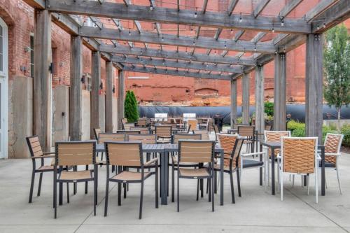 a group of tables and chairs in a patio at Urban Escape Industrial 2BR 2BA in Greenville