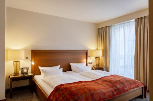 a hotel room with a large bed and a window at Hotel Alma Am Anger in Erfurt