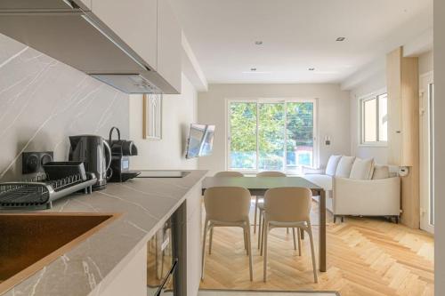 une cuisine et un salon avec une table et des chaises dans l'établissement T2 moderne pour 4 - St-Didier-au-Mont-d'Or, à Saint-Didier-au-Mont-dʼOr