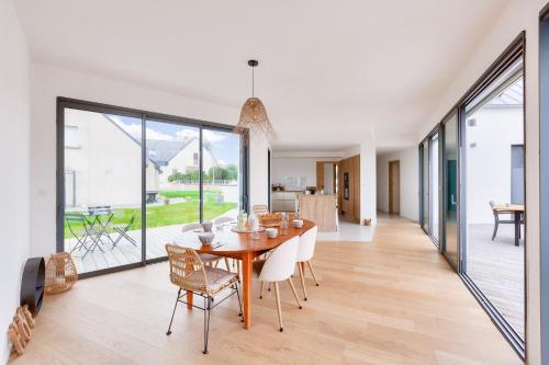 une salle à manger avec une table et des chaises en bois dans l'établissement 800m de la plage, maison neuve pour 10, piscine, à Pléneuf-Val-André