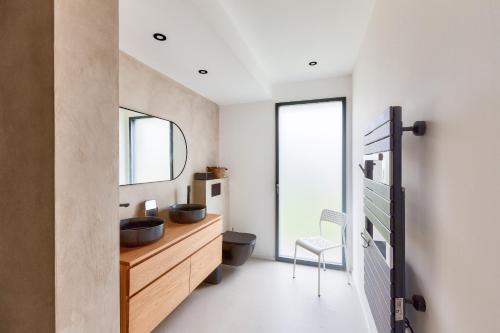 a bathroom with a wooden dresser and a mirror at 800m de la plage, maison neuve pour 10, piscine in Pléneuf-Val-André