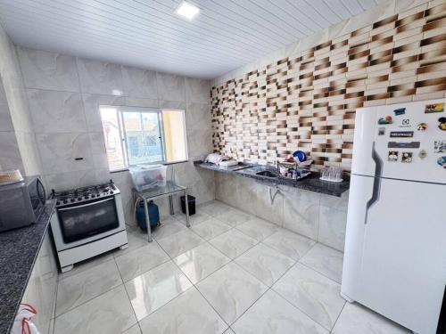 a kitchen with a white refrigerator and a stove at Apartamento em Mundaú in Trairi