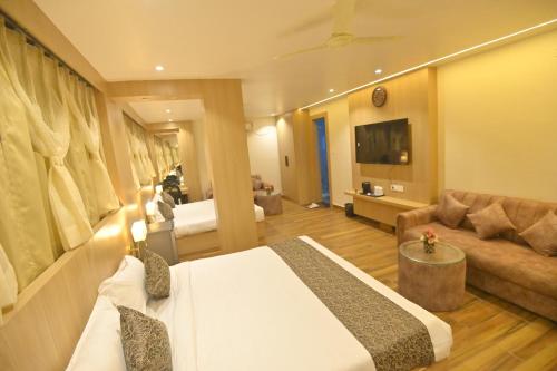 a hotel room with a bed and a couch at Hotel JK palace in Allahābād