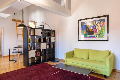 a living room with a couch and a book shelf at Hotel Alma Am Anger in Erfurt