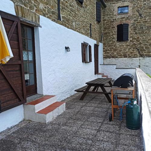 a picnic table and a picnic table next to a building at Agriturismo Alla Vecchia Quercia in Pergola