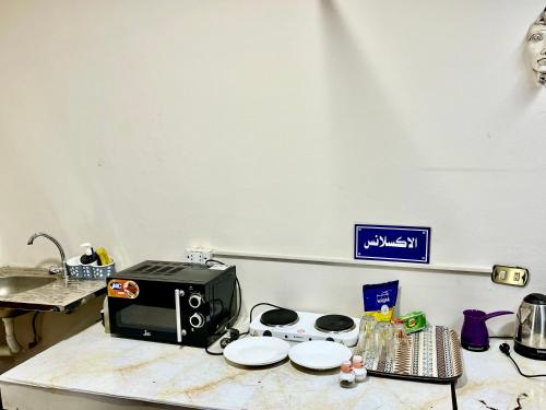 a kitchen counter with a microwave on top of it at Akh Pyramid Hostel in Cairo