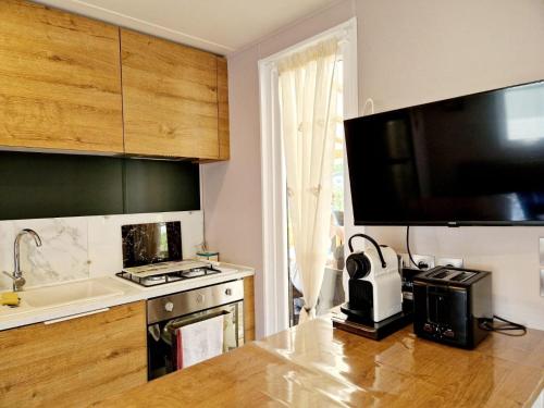 une cuisine avec un évier et une cuisinière four supérieur dans l'établissement Camping Del Mar 52, Mobile Home Excellence, 3 chambres, 6 personnes, bord de mer, à Argelès-sur-Mer