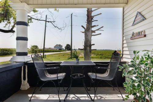 una mesa y 4 sillas en un porche con una mesa y una ventana en Broadview Manor, en Kempton
