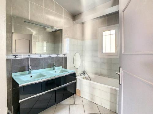 une salle de bain avec un lavabo, une baignoire et un miroir dans l'établissement Les Crès Ricards, à Ceyras