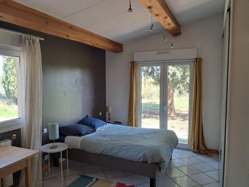 une chambre avec un lit et une grande fenêtre dans l'établissement Les Crès Ricards, à Ceyras