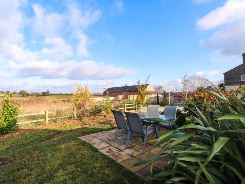 a patio with a table and chairs in a yard at Yocking Gate Mews in Whitchurch