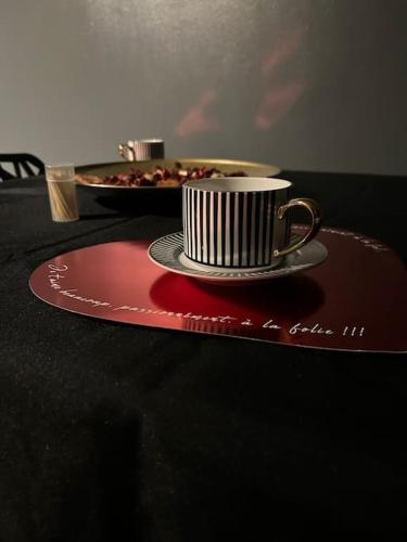 une tasse de café sur un plateau rouge sur une table dans l'établissement Love-cocon sur mantes sur mante, à Mantes-la-Jolie