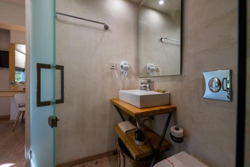 a bathroom with a sink and a mirror at Panellinion Luxury Rooms in Kalamata