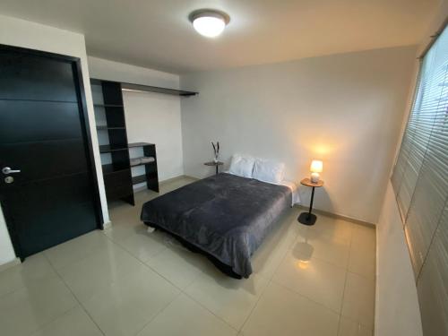 a bedroom with a bed and a lamp and a door at Estancia Iturriaga Suite 2 in Mexico City