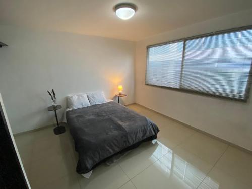 a bedroom with a bed and a large window at Estancia Iturriaga Suite 2 in Mexico City
