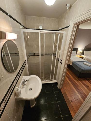 a bathroom with a sink and a shower and a bed at 8 Clos Na Feirme Three Bedroom House with Hot Tub in Galway