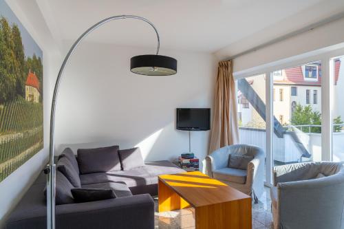 a living room with a couch and two chairs and a table at Hotel Alma Am Anger in Erfurt