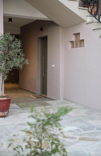 a hallway of a building with a door and a plant at Trikala Wander Stay in Tríkala