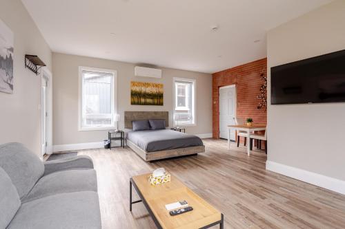 a living room with a bed and a table at ENTIRE BACHELOR UNIT EN-SUITE ACROSS FROM GOOGLE - br3 in Kitchener