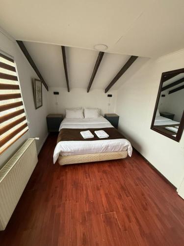 a bedroom with a large bed and a wooden floor at Cabañas Última Esperanza in Puerto Natales