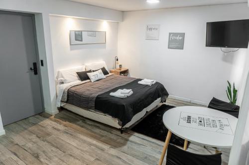 a bedroom with a bed and a table and a tv at Departamento Glamour 203 - Edificio VILAUT by INMOVE Temporarios in Córdoba