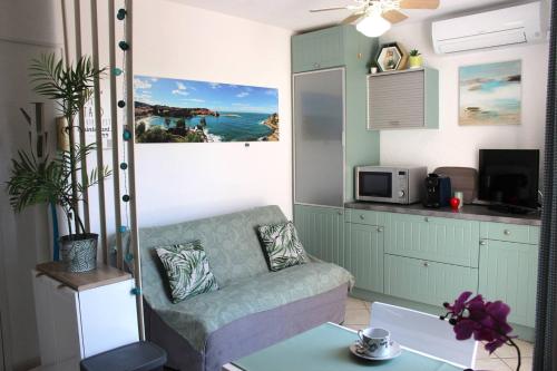 un salon avec un canapé et une table dans l'établissement Charmant T2 climatisé au cœur de Saint Cyprien plage - 4MIR23, à Saint Cyprien Plage