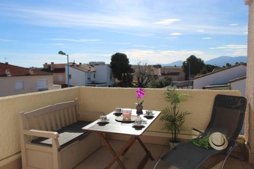un balcon avec une table et des chaises sur un balcon dans l'établissement Charmant T2 climatisé au cœur de Saint Cyprien plage - 4MIR23, à Saint Cyprien Plage