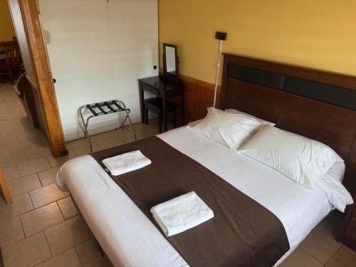 a bedroom with a large bed with two towels on it at Cabañas Última Esperanza in Puerto Natales