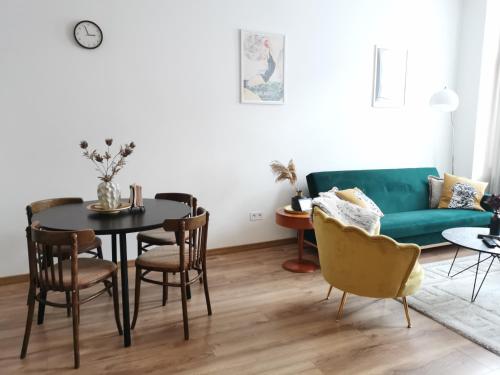 a living room with a green couch and a table and chairs at Atlas Apartment in the historical center of Košice with free private parking in Košice