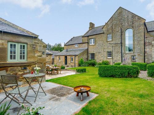 a garden with a table and chairs and a building at The Stable - Uk35021 in Long Houghton