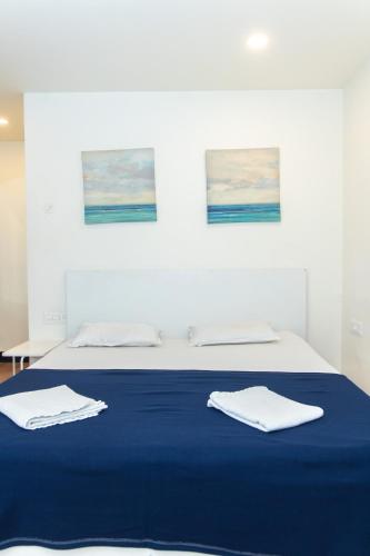 a bedroom with a blue bed with two towels on it at Slackpackr Hyderabad in Hyderabad