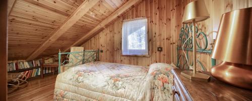 シャンポルクにある5' Bus to the Ski Slopes, Panoramic Chaletの木造キャビン内のベッド1台が備わるベッドルーム1室を利用します。
