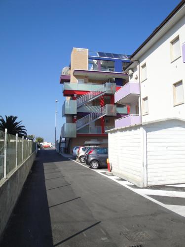a building with a car parked in a parking lot at Residence La Nave in Senigallia