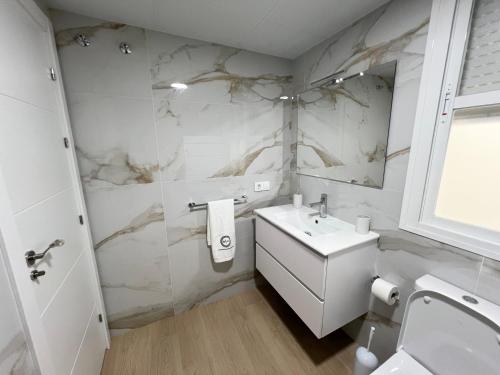 a white bathroom with a sink and a mirror at Apartment Arevalo 2B Parking Gratis in Lucena