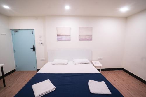 a white room with a large bed with two pillows at Slackpackr Hyderabad in Hyderabad