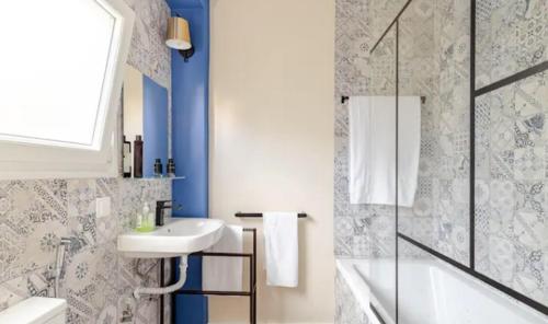a white bathroom with a sink and a shower at Refreshed apartment with private garden in Almada