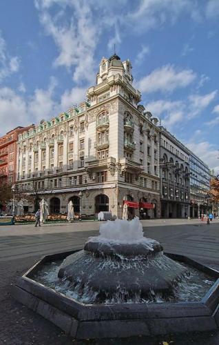 a building with a fountain in front of a building at The Horse Monument Hostel in Belgrade