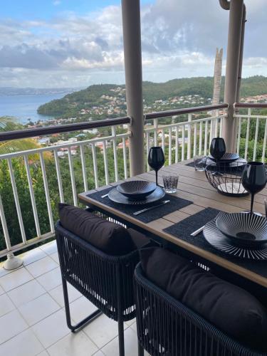 a table on a balcony with a view of the ocean at Villa Ansalane in Quartiers Anse à lʼÂne